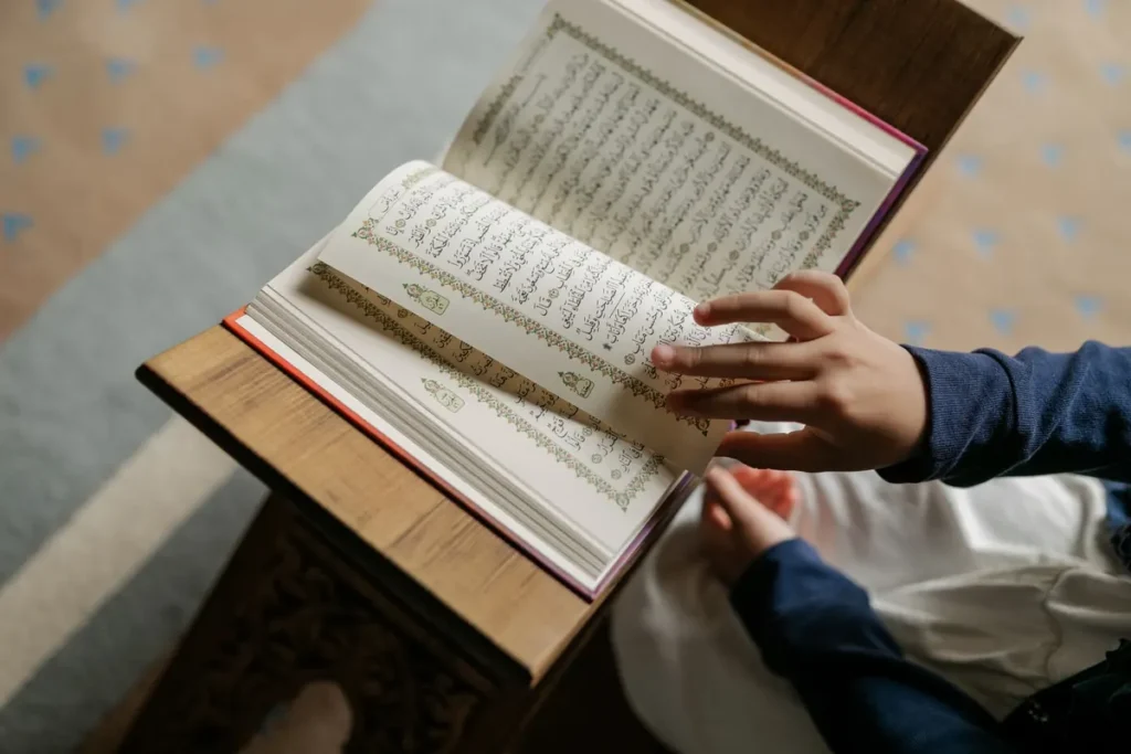 Child reading the Quran on a wooden rehal